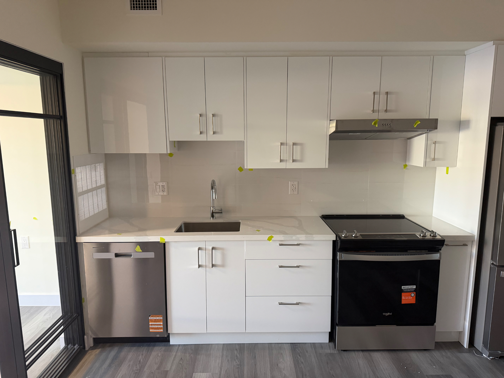 Finished kitchen with white cabinets, stone countertops and stainless steel appliances