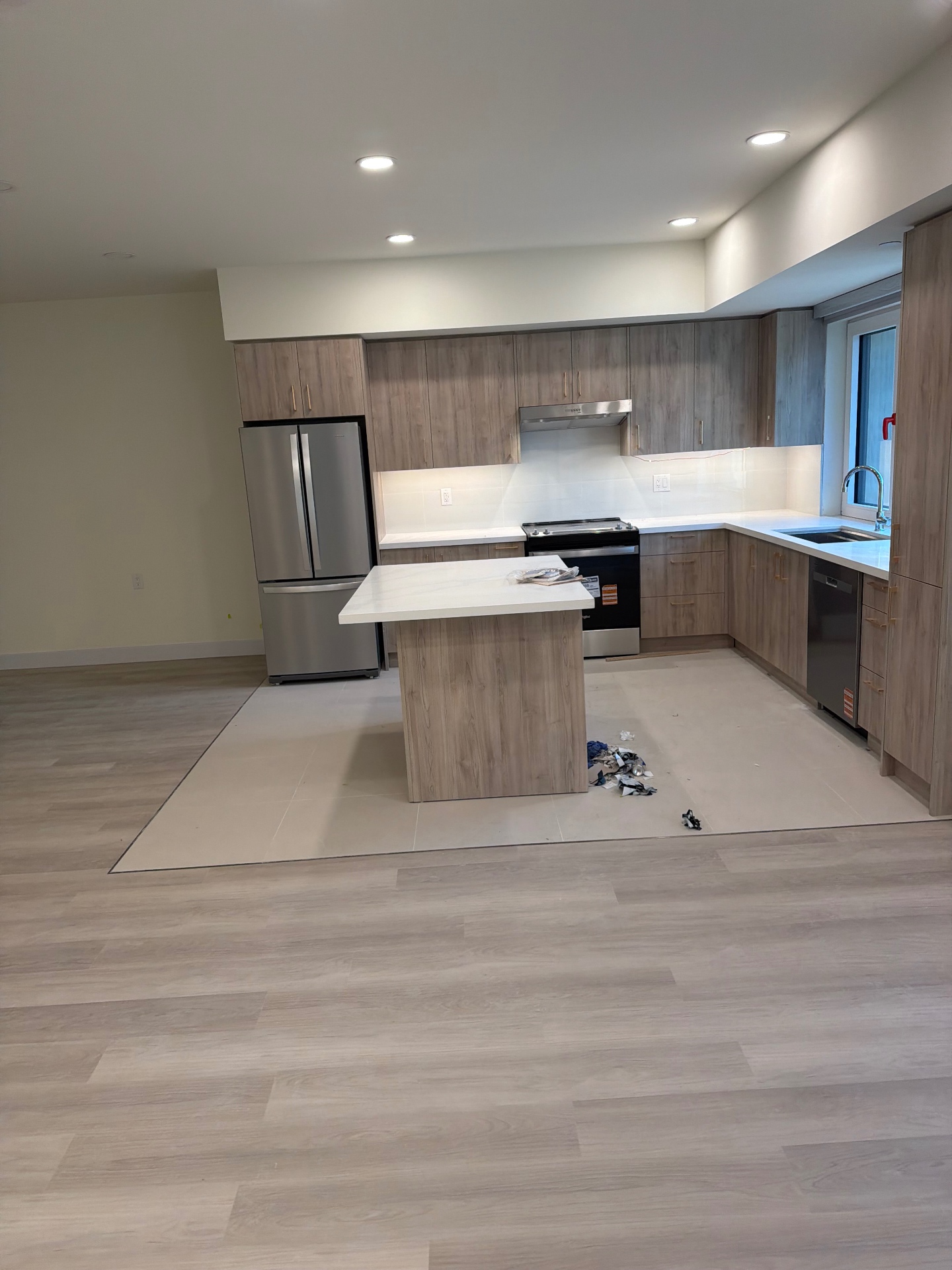 Renovated kitchen with wood-grain cabinets, a central island and white quartz countertops